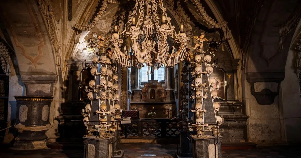 A vaulted chapel lined with bones and skulls, a chandelier of bones hanging in the centre